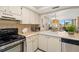 Bright kitchen with stainless appliances, white cabinets, and a view of the living area at 6357 Bahia Del Mar Blvd # 403, St Petersburg, FL 33715