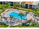Aerial view of a community pool with lounge chairs, palm trees, and beautiful landscaping at 6357 Bahia Del Mar Blvd # 403, St Petersburg, FL 33715