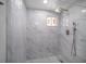 Modern bathroom featuring gray tile, walk-in shower, and rain shower head at 7136 Isle Dr, Port Richey, FL 34668