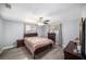 Cozy bedroom with wood-look floors, ceiling fan, neutral decor, and plenty of natural light from two windows at 7136 Isle Dr, Port Richey, FL 34668