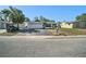 Street view showcasing the home with a two-car garage, contrasted against a bright sky and surrounding foliage at 7136 Isle Dr, Port Richey, FL 34668