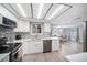 Modern kitchen with white cabinetry, stainless steel appliances, mosaic backsplash, and breakfast bar at 7136 Isle Dr, Port Richey, FL 34668