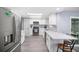 Updated kitchen with stainless steel fridge, white cabinets, mosaic backsplash, and a cozy breakfast nook at 7136 Isle Dr, Port Richey, FL 34668