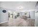 Open concept living room with light gray wood flooring, modern lighting, and a dining area at 7136 Isle Dr, Port Richey, FL 34668