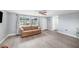 Bright living room featuring a ceiling fan, a comfy sofa, and beautiful flooring at 7136 Isle Dr, Port Richey, FL 34668