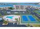 This aerial view highlights the community pool, tennis courts, parking area, and building's surroundings at 7700 Sun Island S Dr # 107, South Pasadena, FL 33707
