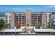 Aerial view of a condo building with a covered parking lot, landscaping, and waterfront in the background at 7700 Sun Island S Dr # 107, South Pasadena, FL 33707