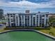 Rear exterior view of the condo building overlooking green space and Boca Ciega Bay at 7700 Sun Island S Dr # 107, South Pasadena, FL 33707