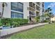 Exterior shot of a condo building with plants, walking path and a covered patio with furniture at 7700 Sun Island S Dr # 107, South Pasadena, FL 33707