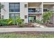 Exterior shot of a condo building with plants, walking path and a covered patio with furniture at 7700 Sun Island S Dr # 107, South Pasadena, FL 33707