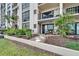 Exterior shot of a condo building with plants, walking path and a covered patio with furniture at 7700 Sun Island S Dr # 107, South Pasadena, FL 33707
