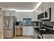 Galley kitchen with stainless steel appliances, granite countertops, and subway tile backsplash at 7700 Sun Island S Dr # 107, South Pasadena, FL 33707