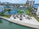 An aerial shot features tiki hut picnic areas and the nearby tennis courts and waterfront at 7700 Sun Island S Dr # 107, South Pasadena, FL 33707
