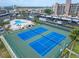 Well-maintained tennis courts offer an active lifestyle with the condo building in the background at 7700 Sun Island S Dr # 107, South Pasadena, FL 33707