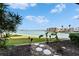 Beautiful waterfront view with lush green lawn, plants and trees, walking path, and residential building at 7700 Sun Island S Dr # 107, South Pasadena, FL 33707