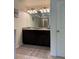 Bathroom with dual sink vanity, large mirror, and shower with glass doors at 8273 Artisan Way, Seminole, FL 33777