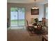 Cozy dining area with a glass table, decorative chandelier, and sliding glass doors at 8273 Artisan Way, Seminole, FL 33777