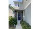 Home featuring a front door with dark gray siding and mature landscaping at 8273 Artisan Way, Seminole, FL 33777