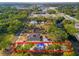A high aerial view depicts the property's setting amidst green trees and nearby roads at 8615 Jackson Springs Rd, Tampa, FL 33615
