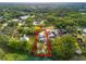 An aerial view displays the property along the water, surrounded by verdant trees and neighborhood homes at 8615 Jackson Springs Rd, Tampa, FL 33615