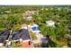 An aerial view shows houses and trees in a neighborhood with a property covered in a blue tarp at 8615 Jackson Springs Rd, Tampa, FL 33615
