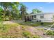 Backyard view showing a gravel area and a glimpse of the house with a covered porch at 8615 Jackson Springs Rd, Tampa, FL 33615
