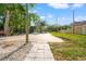 Long concrete driveway provides ample parking space, surrounded by grass and trees at 8615 Jackson Springs Rd, Tampa, FL 33615