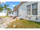 Exterior of home on a sunny day, set on a gravel lot with a shed and vegetation at 8615 Jackson Springs Rd, Tampa, FL 33615