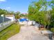 A single-story home is seen in an aerial shot with a large driveway and trees. The roof is covered with a blue tarp at 8615 Jackson Springs Rd, Tampa, FL 33615