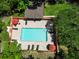 Aerial view of the community pool with brick pavers, tables, lounge chairs, and green landscaping at 8901 Casablanca Way, Tampa, FL 33626