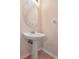 Bathroom with an oval mirror, pedestal sink and a neutral color palette at 8901 Casablanca Way, Tampa, FL 33626