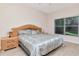Neutral bedroom featuring a large window, wood nightstand, and comfortable bed at 8901 Casablanca Way, Tampa, FL 33626