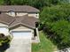 Aerial view of a two story tan townhome with a garage and landscaped yard at 8901 Casablanca Way, Tampa, FL 33626