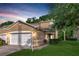 Charming two-story townhouse with a two-car garage, manicured lawn, and lush greenery set against a beautiful sunset at 8901 Casablanca Way, Tampa, FL 33626