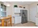 Eat-in kitchen featuring stainless steel refrigerator, white cabinets, and a bright window at 8901 Casablanca Way, Tampa, FL 33626