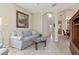 Open living room with a large couch, glass coffee table, and light wood flooring leading to the staircase at 8901 Casablanca Way, Tampa, FL 33626