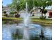 Community pond with a fountain and picturesque views of colorful homes at 8901 Casablanca Way, Tampa, FL 33626