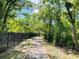 Scenic path lined with lush greenery and a black fence at 8901 Casablanca Way, Tampa, FL 33626