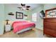 Comfortable bedroom with carpeted floors, ceiling fan, dresser, and mounted TV at 921 24Th N Ave, St Petersburg, FL 33704
