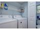 Laundry room includes a washer, dryer, shelving, and a partially visible toilet at 921 24Th N Ave, St Petersburg, FL 33704