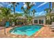 Lush backyard featuring a stunning pool, tiki bar, and comfortable lounge chairs at 921 24Th N Ave, St Petersburg, FL 33704