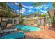 Stunning pool area with lush tropical landscaping and a tiki hut, perfect for outdoor entertaining and relaxation at 921 24Th N Ave, St Petersburg, FL 33704