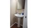 This powder room features a pedestal sink, a mirror, and stylish wallpaper at 921 24Th N Ave, St Petersburg, FL 33704