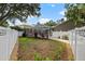 Spacious backyard with a privacy fence, greenery, and a screened-in pool at 9322 Wellington Park Cir, Tampa, FL 33647