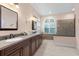 Spacious bathroom featuring double sinks, granite counters, and a window for natural light at 9322 Wellington Park Cir, Tampa, FL 33647