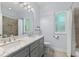 Bright bathroom featuring a double sink vanity with marble countertop, modern fixtures, and a walk-in shower at 9322 Wellington Park Cir, Tampa, FL 33647