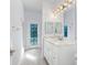 Well-lit bathroom featuring modern lighting, a large mirror, and a vanity with marble countertop at 9322 Wellington Park Cir, Tampa, FL 33647