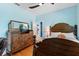 Tranquil bedroom featuring hardwood floors, a decorative dresser, and a comfortable bed at 9322 Wellington Park Cir, Tampa, FL 33647