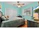 Comfortable bedroom offering natural light, hardwood floors, a ceiling fan, and a view of the backyard at 9322 Wellington Park Cir, Tampa, FL 33647