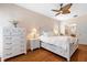 Charming bedroom with a white bed frame, hardwood floors, and a ceiling fan at 9322 Wellington Park Cir, Tampa, FL 33647